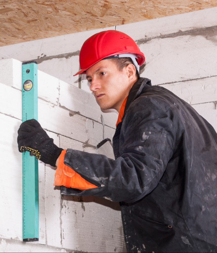 worker measuring a concrete wall