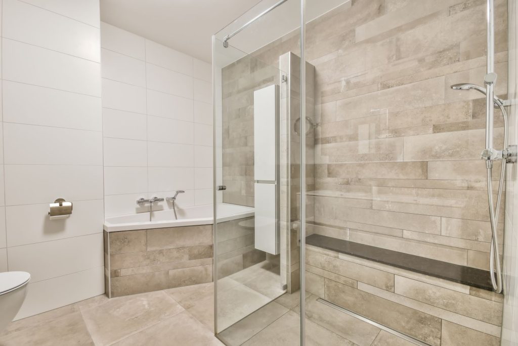 A spacious modern bathroom featuring a seamless glass shower door.