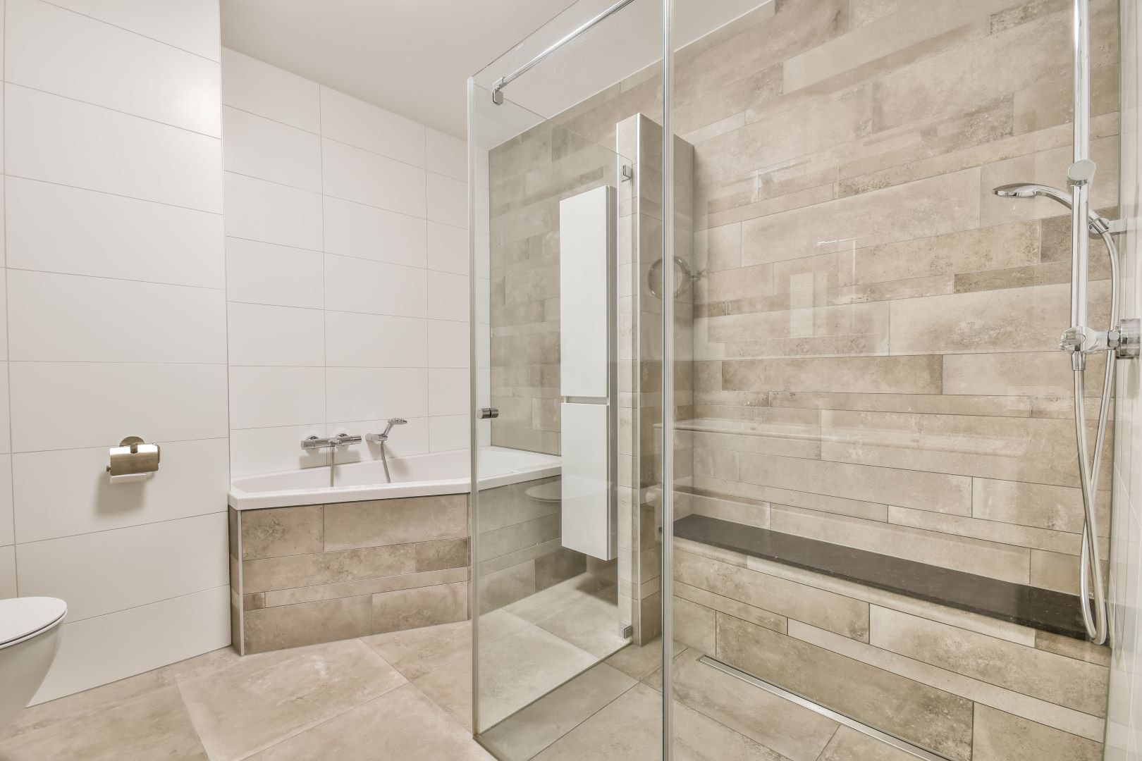 A spacious modern bathroom featuring a seamless glass shower door.