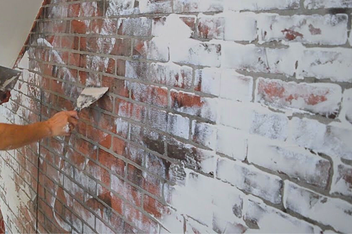 Mason applies the German Schmear technique to a brick wall