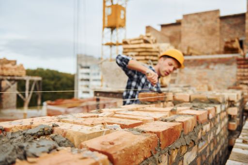 Construction worker in uniform and safety equipment have job on building.